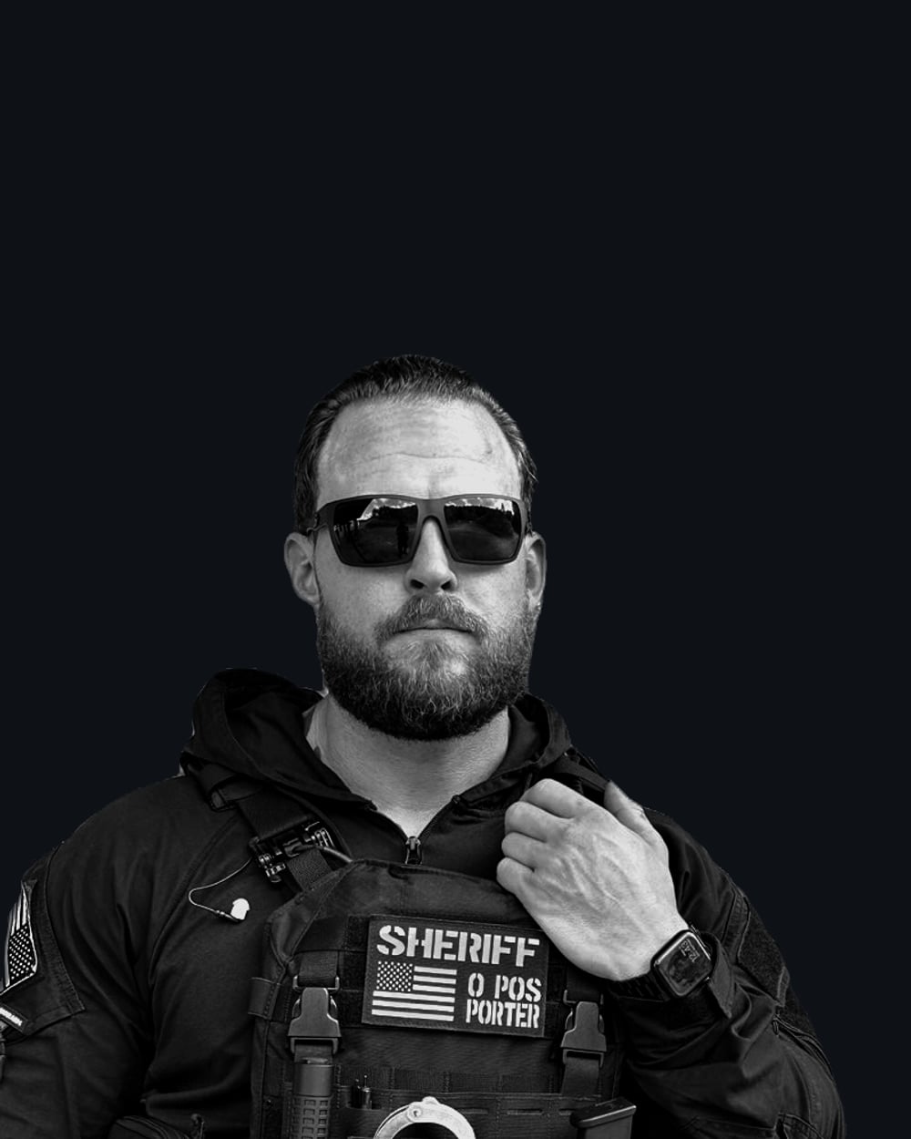 Josh in plate carrier and shades, B&W portrait